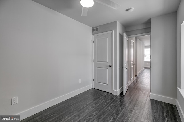 spare room with ceiling fan and dark wood-type flooring