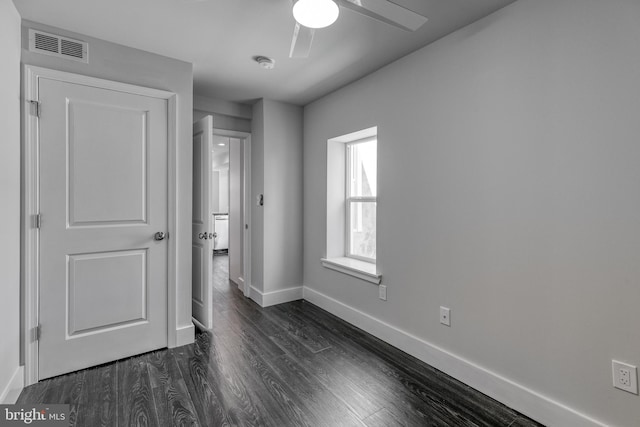 unfurnished bedroom featuring dark hardwood / wood-style floors and ceiling fan