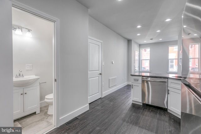 kitchen featuring sink, stainless steel dishwasher, dark hardwood / wood-style floors, and white cabinets