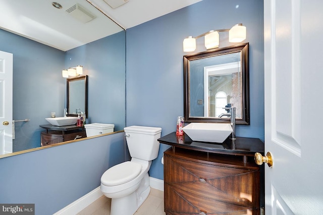 bathroom featuring toilet, tile patterned flooring, and vanity