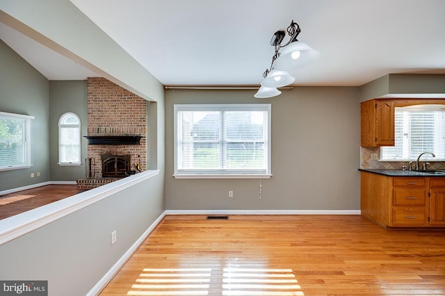 kitchen with a healthy amount of sunlight, light hardwood / wood-style floors, and backsplash