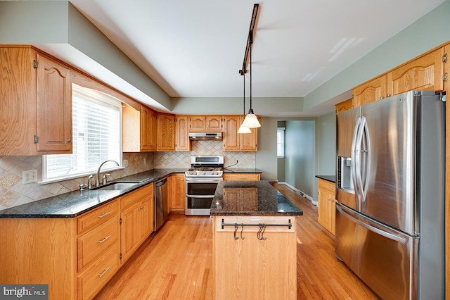 kitchen featuring sink, a center island, stainless steel appliances, and light hardwood / wood-style flooring