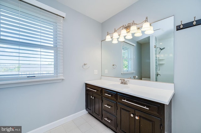 bathroom with tile patterned flooring, a shower, vanity, and a wealth of natural light