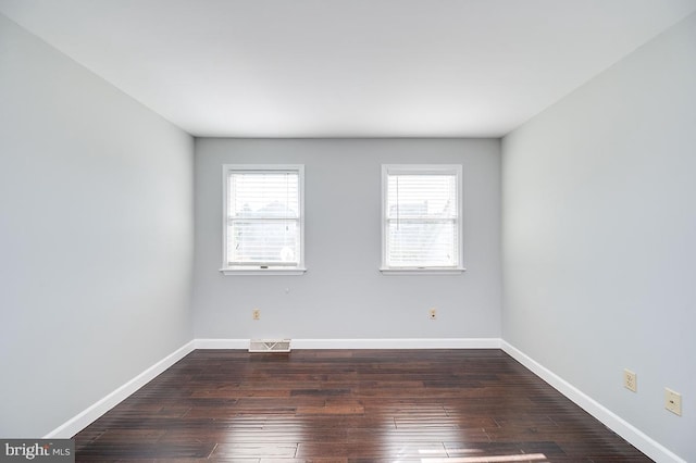 empty room with dark hardwood / wood-style flooring