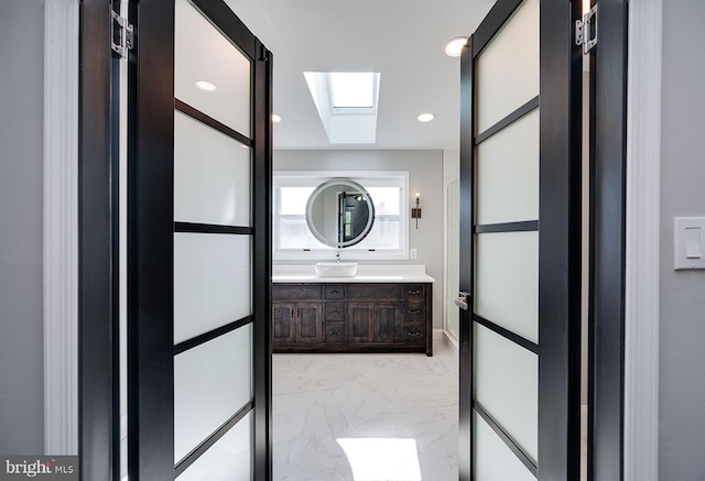 bathroom with a skylight and vanity