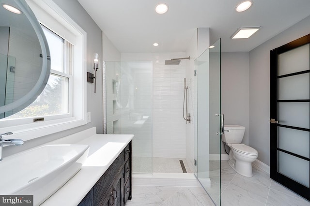 bathroom featuring vanity, toilet, and a shower with shower door