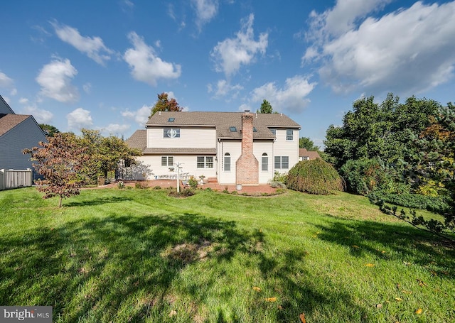 rear view of property with a yard