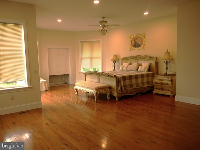 bedroom with wood-type flooring, multiple windows, and ceiling fan