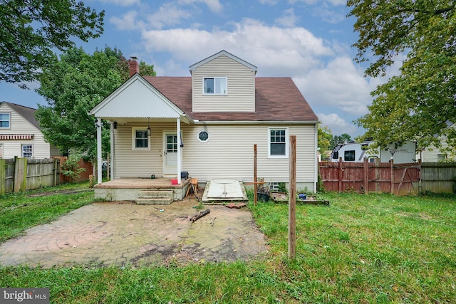 rear view of property with a lawn and a patio