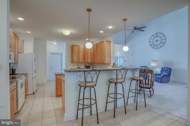 kitchen featuring kitchen peninsula, a kitchen breakfast bar, ceiling fan, white appliances, and light colored carpet