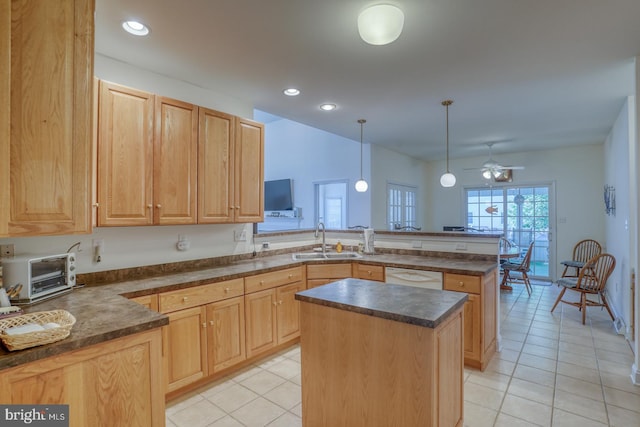 kitchen with white dishwasher, kitchen peninsula, hanging light fixtures, sink, and a kitchen island