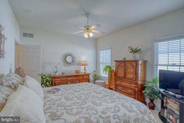 bedroom with ceiling fan, multiple windows, and carpet