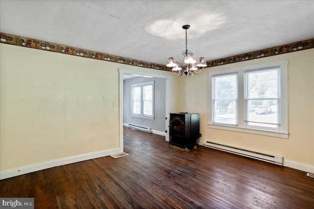 unfurnished dining area featuring a wood stove, a healthy amount of sunlight, and baseboard heating