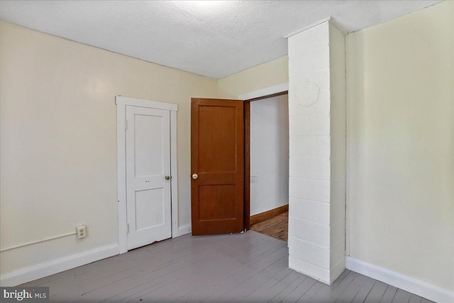 empty room with a textured ceiling and light wood-type flooring