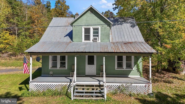 view of front of home featuring a porch, a front lawn, and cooling unit