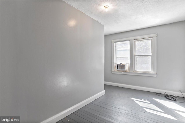 unfurnished room with hardwood / wood-style flooring and a textured ceiling