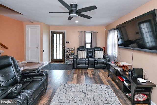 living room featuring ceiling fan and dark wood-type flooring