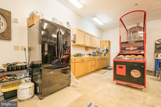 kitchen featuring light brown cabinetry and fridge