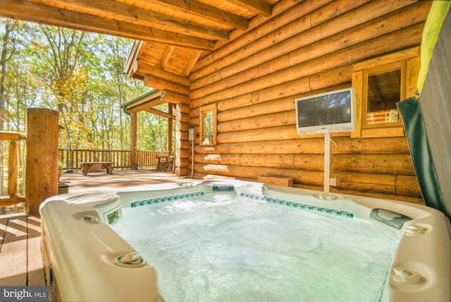 view of pool with a hot tub and a deck