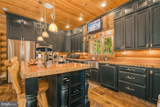 kitchen featuring wood ceiling, hardwood / wood-style flooring, wood counters, sink, and decorative light fixtures