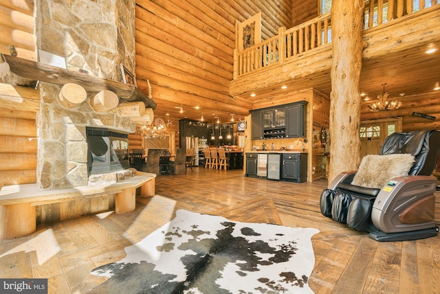 living room with hardwood / wood-style floors, a high ceiling, rustic walls, and a stone fireplace