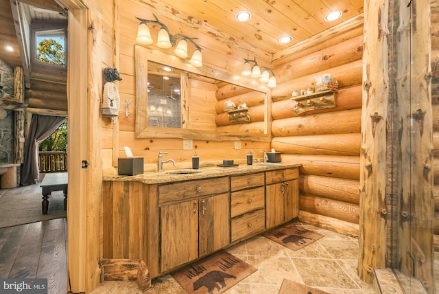 bathroom featuring vanity, wood-type flooring, rustic walls, and a wealth of natural light