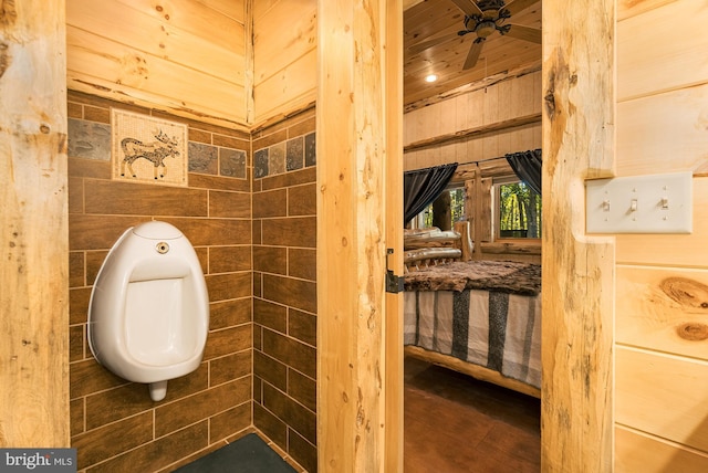 bathroom with wooden walls and toilet