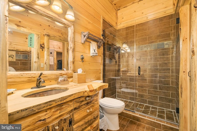 bathroom with wood walls, a shower with shower door, toilet, tile patterned floors, and vanity