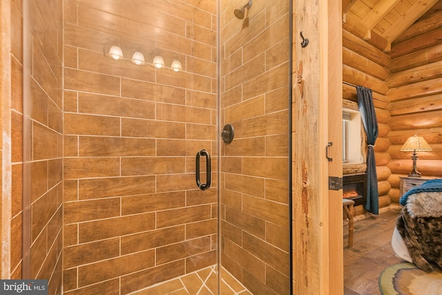 bathroom with a shower with door, log walls, and vaulted ceiling