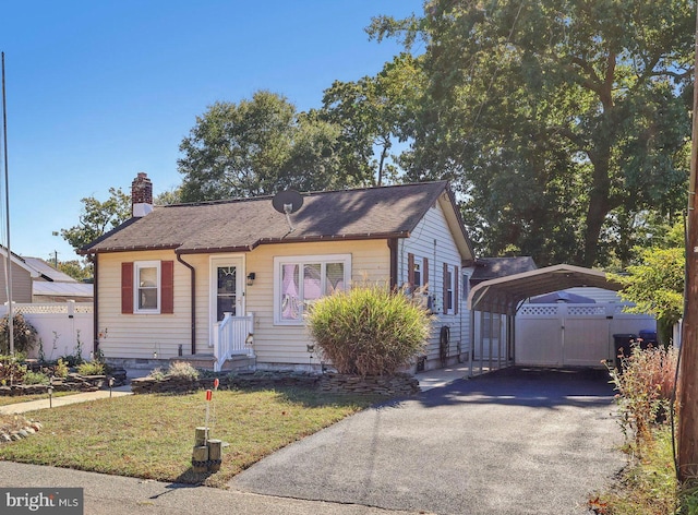 bungalow-style home with a front lawn and a carport