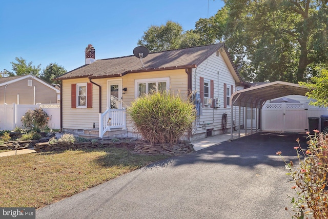 bungalow-style home featuring a front lawn and a carport