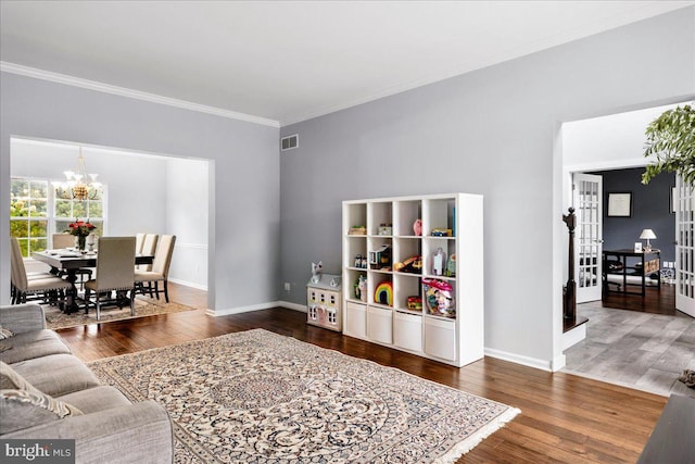 living room featuring ornamental molding, french doors, dark hardwood / wood-style floors, and a chandelier