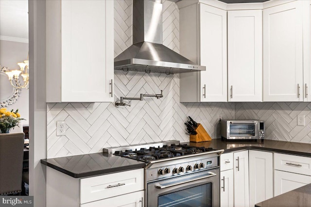 kitchen featuring wall chimney exhaust hood, white cabinets, and high end stainless steel range