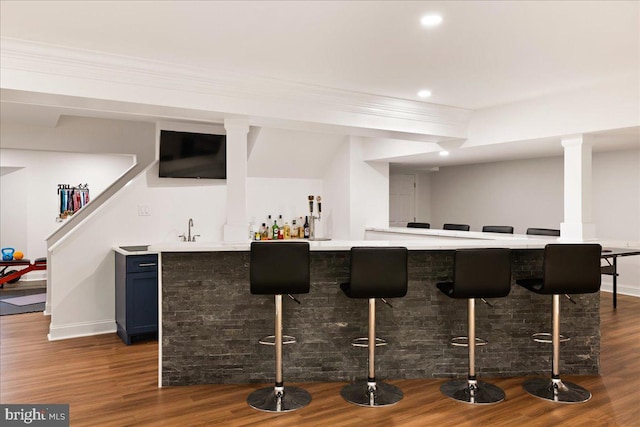 bar featuring blue cabinetry, sink, and dark hardwood / wood-style flooring