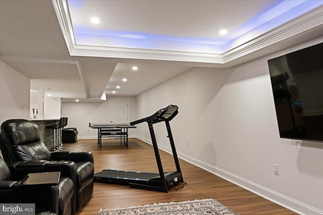 exercise area with hardwood / wood-style floors and a tray ceiling