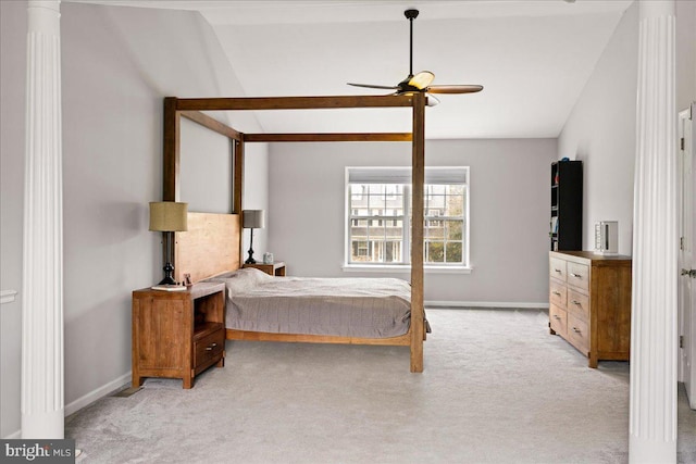 carpeted bedroom featuring decorative columns, vaulted ceiling, and ceiling fan