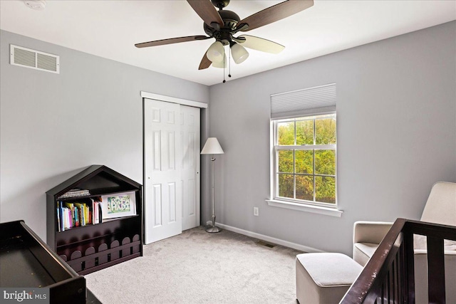 carpeted bedroom featuring a closet and ceiling fan