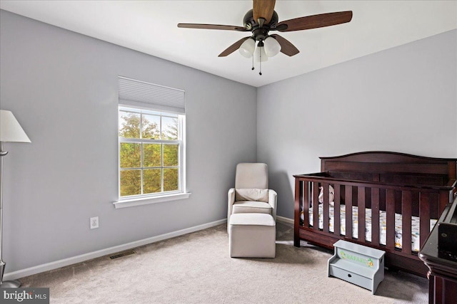 bedroom featuring ceiling fan, carpet, and a nursery area