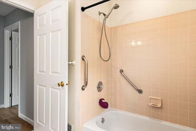 bathroom with hardwood / wood-style floors and tiled shower / bath combo