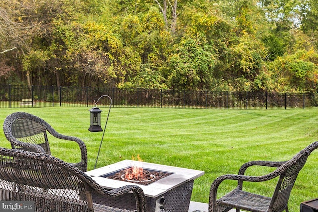 surrounding community featuring a lawn and a fire pit