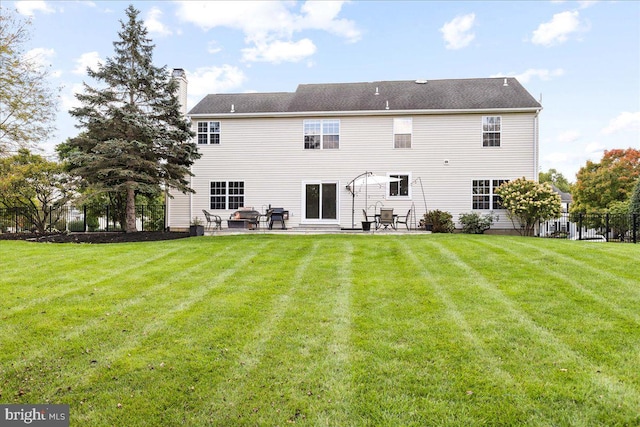 rear view of house with a patio and a lawn