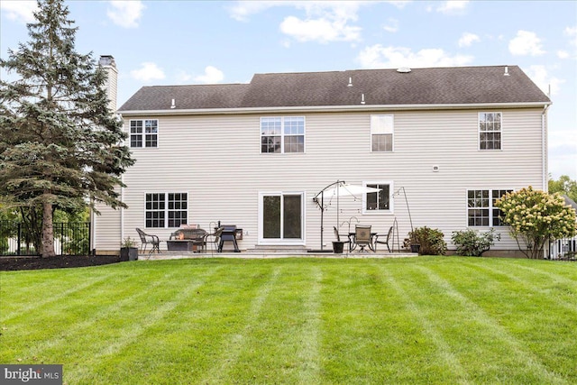 rear view of house with a yard and a patio