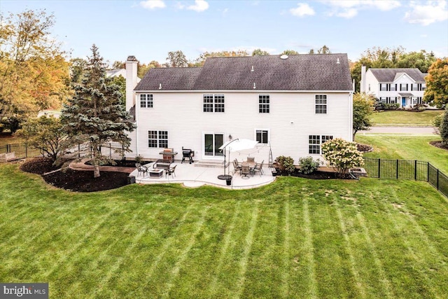 back of property with a yard and a patio