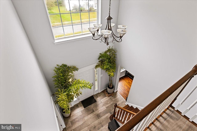 entryway with wood-type flooring and an inviting chandelier