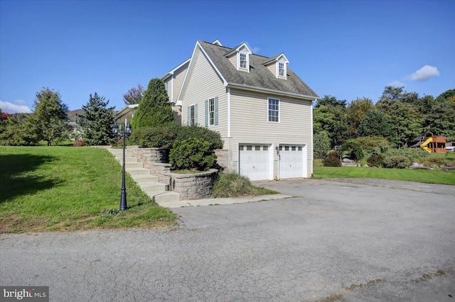 view of side of property featuring a garage and a lawn