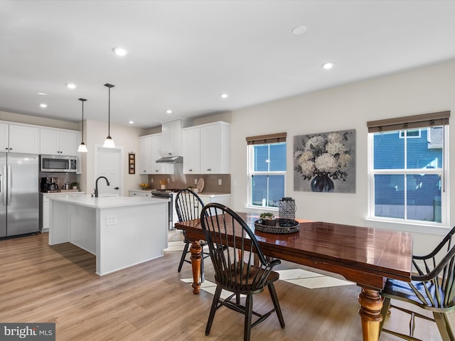 dining space with light hardwood / wood-style flooring and sink