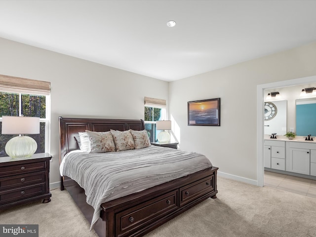 bedroom with light colored carpet and connected bathroom