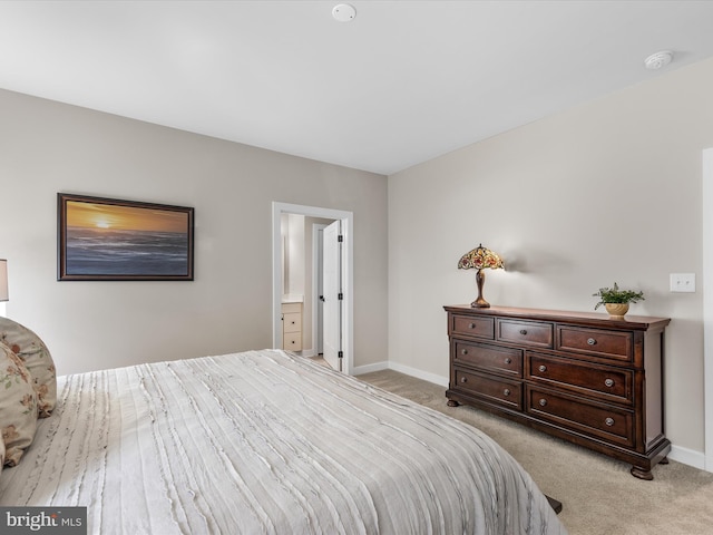 bedroom featuring ensuite bathroom and light carpet