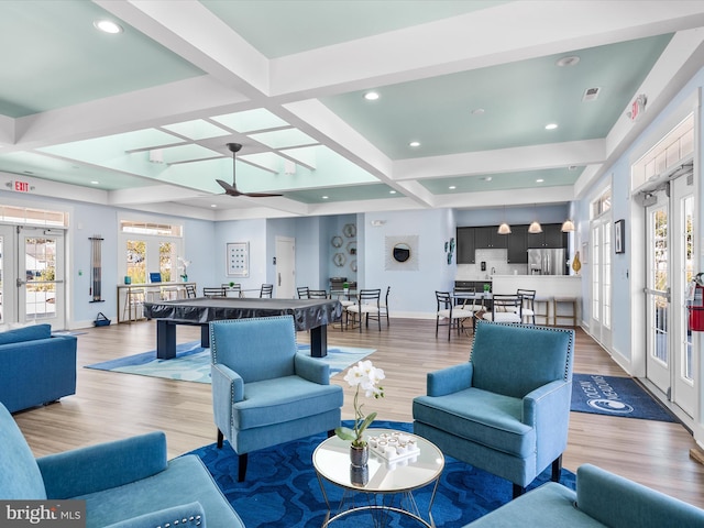 living room featuring light wood-type flooring, ceiling fan, beam ceiling, coffered ceiling, and french doors