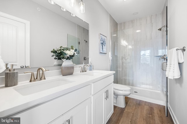 bathroom with wood-type flooring, vanity, toilet, and an enclosed shower